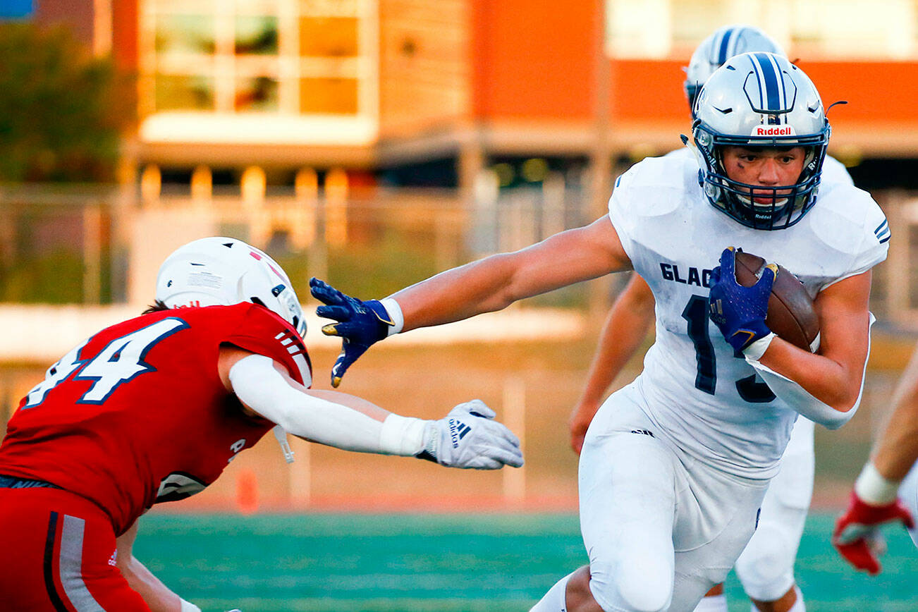 Glacier Peak's Trey Leckner rushes with Snohomish's Kaden Alexander attempting a tackle Friday night at Veteran's Memorial Stadium in Snohomish September 3, 2021. (Kevin Clark / The Herald)