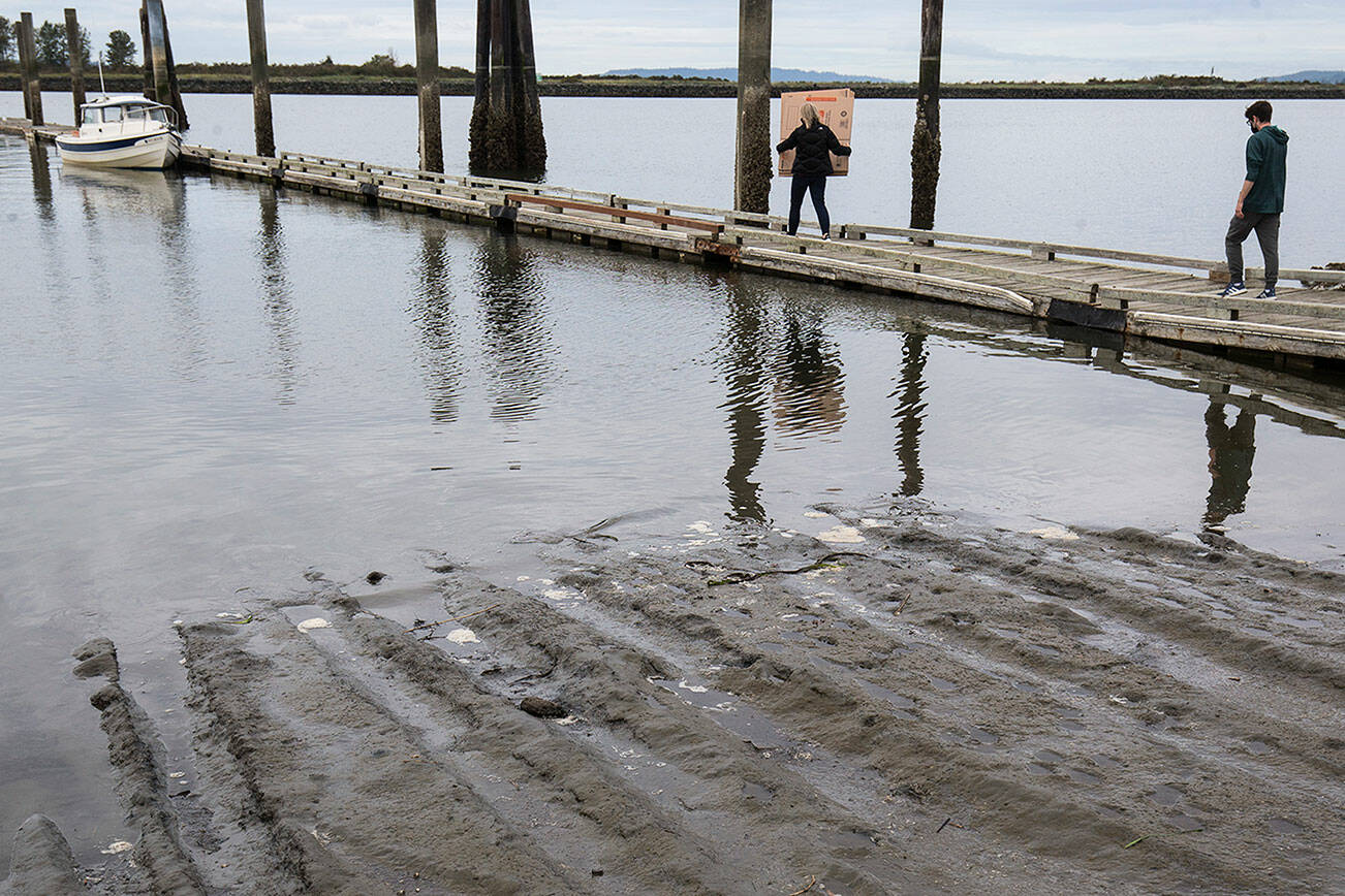 Slit appears in Lane 13 of the 10th Street boat launch as a family hauls items to their boat before heading to Hat Island, on Wednesday, Sept. 22, 2021 in Everett, Washington. Port of Everett officials say sediment has been pouring in at a much greater rate than usual at Everett’s 10th Street Boat Launch. The Port is accepting bids for dredging the launch and the area north of it.  (Andy Bronson / The Herald)