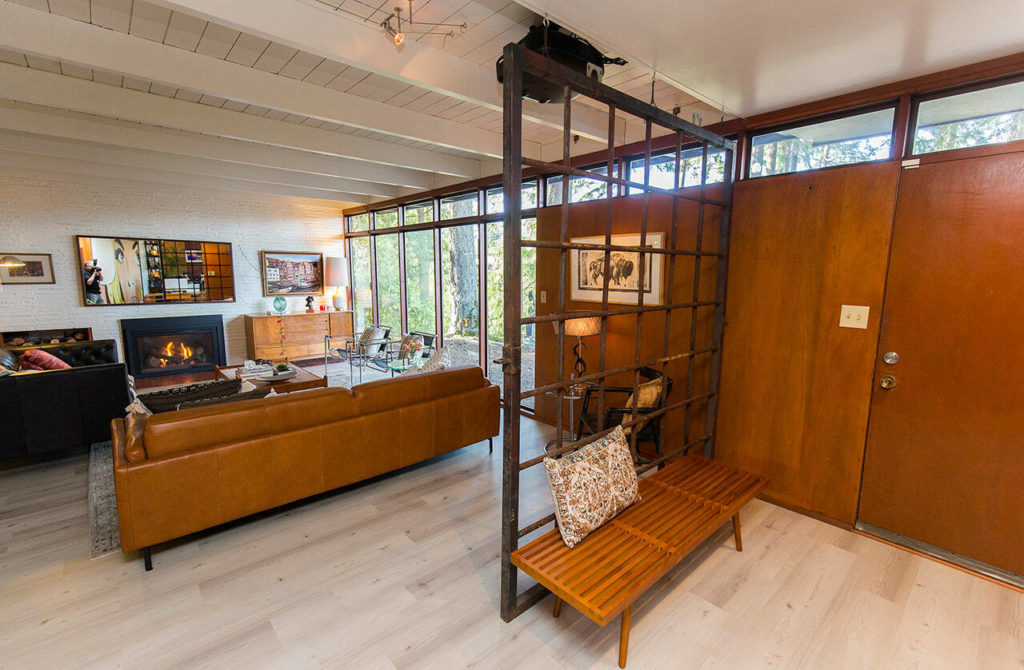 An iron gate separates the entryway from the living room at the Poischbeg home, built in 1950. (Andy Bronson / The Herald)

