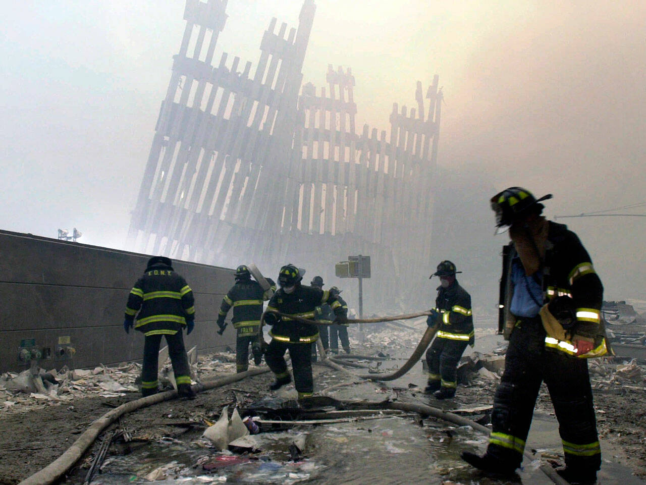 Firefighters work beneath the destroyed mullions, the vertical struts, of the World Trade Center in New York on Tuesday, Sept. 11, 2001. (Mark Lennihan / Associated Press file photo)