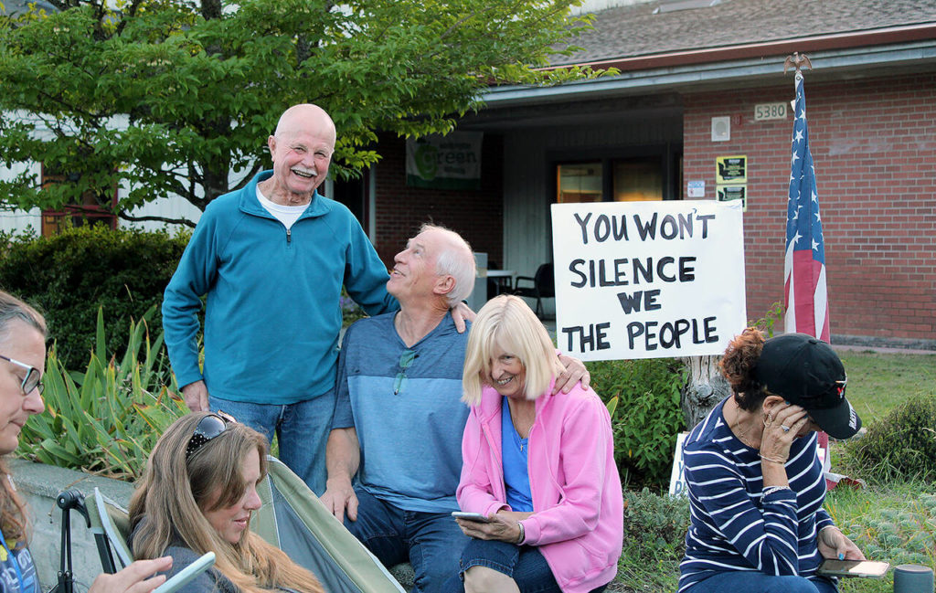 Wayne Flaaten (standing) gathers with other community members to listen to a South Whidbey School District board meeting. (Karina Andrew / Whidbey News-Times)
