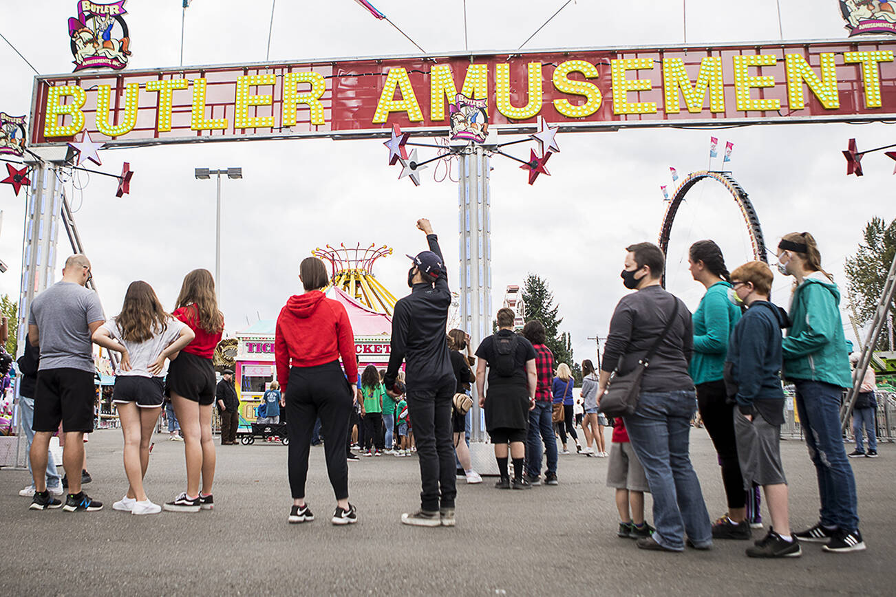 People wait in line for amusement park tickets during opening day of the Evergreen State Fair on Thursday, Aug. 26, 2021 in Monroe, Wash. (Olivia Vanni / The Herald)