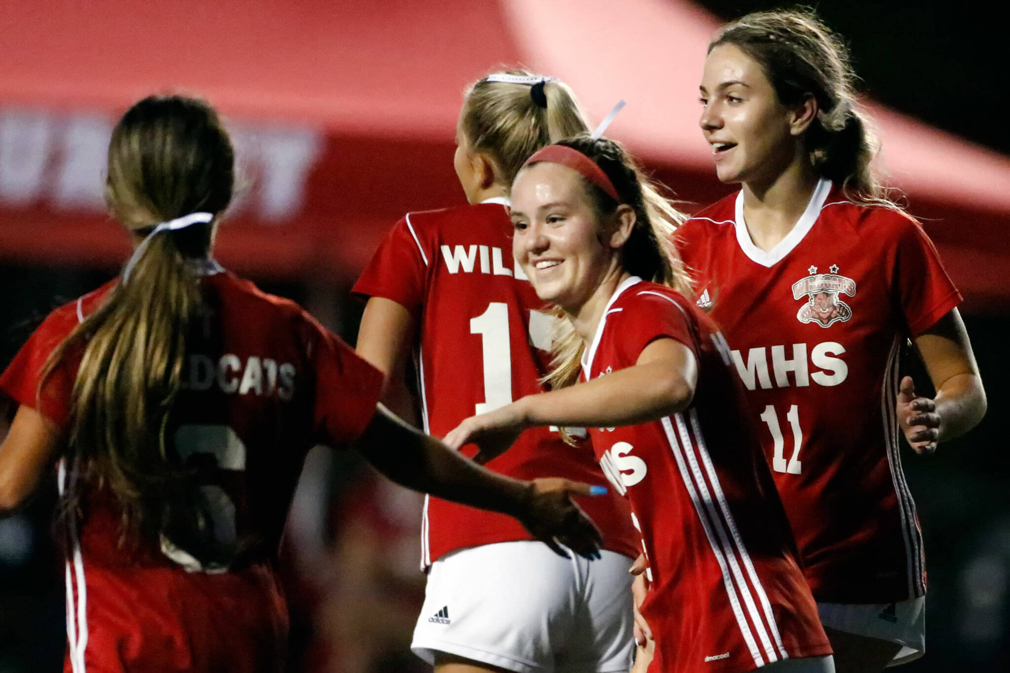 Archbishop Murphy’s Cameron Bourne (center) celebrated her third goal of the night with teammates Jojo Chiangpradit (left) and Taylor Campbell (right) during a game against Arlington on Tuesday night at Archbishop Murphy High School in Everett. The Wildcats won 6-1. (Kevin Clark / The Herald)