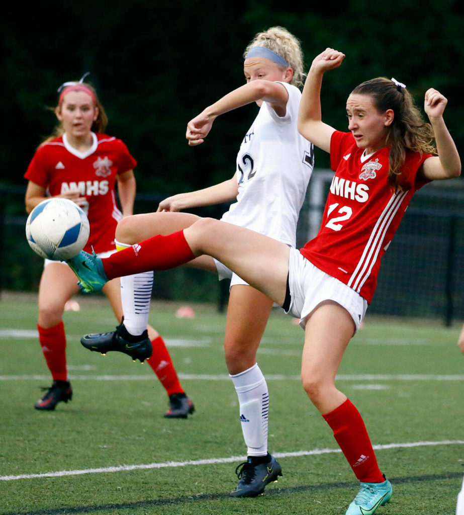 Arlington’s Carly Bartlow, left, and Archbishop Murphy’s Lilia Echols vie the ball at Archbishop Murphy High School Tuesday night in Everett on September 14, 2021. The Wildcats won 6-1. (Kevin Clark / The Herald)
