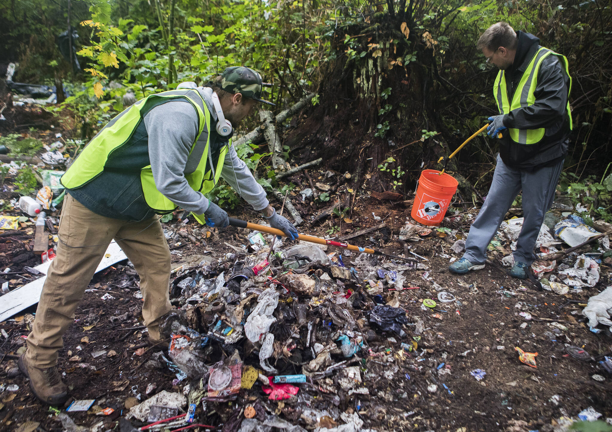 David Rice-Whichers (right) and Justin Dull, volunteers with the Hand Up Project, search for needles Sunday during a cleanup of an encampment along 130th Street SE near Everett. (Olivia Vanni / The Herald)