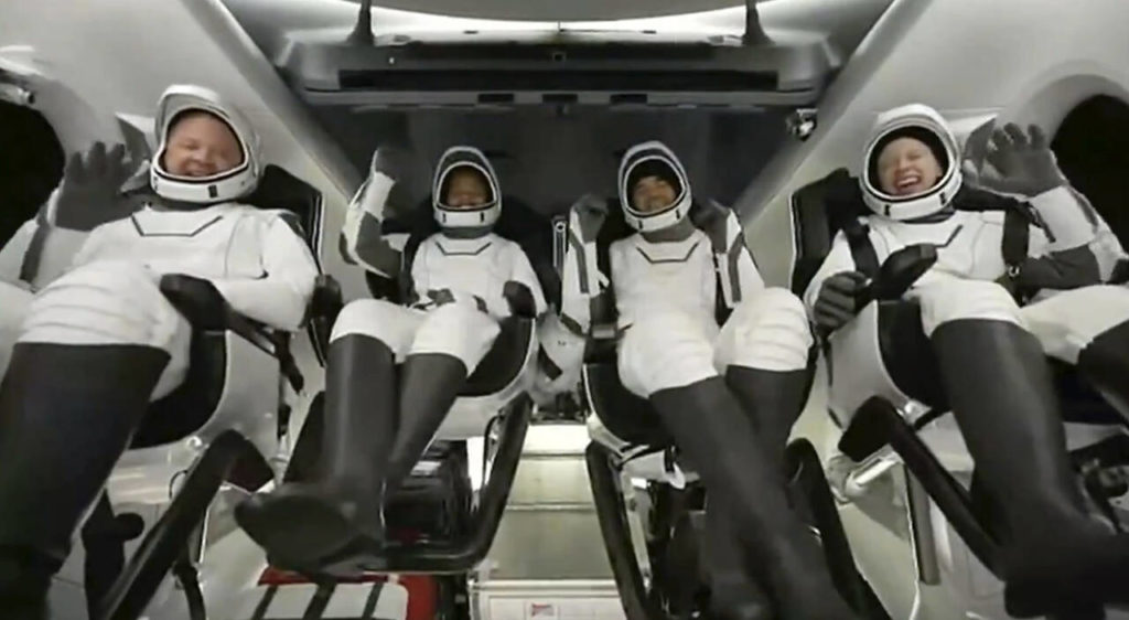 In this image taken from SpaceX video, passengers aboard a SpaceX capsule react as the capsule parachutes into the Atlantic Ocean off the Florida coast Saturday. (SpaceX via AP)
