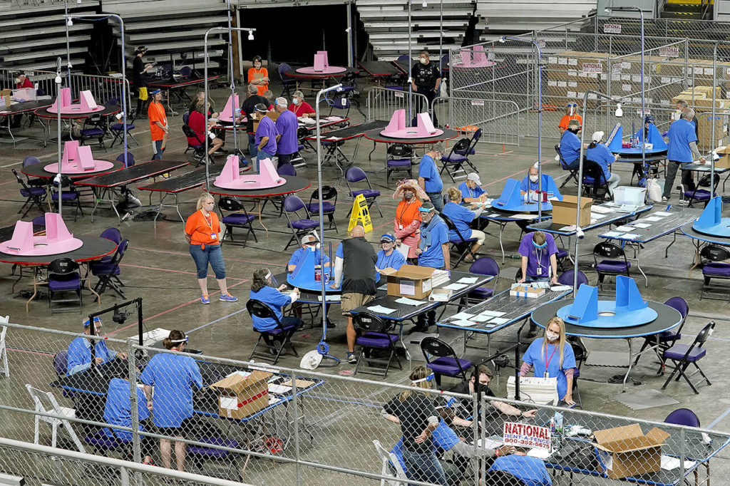 In this May 6 photo, Maricopa County ballots cast in the 2020 general election are examined and recounted by contractors working for Florida-based company Cyber Ninjas at Veterans Memorial Coliseum in Phoenix. (AP Photo/Matt York, Pool, File)
