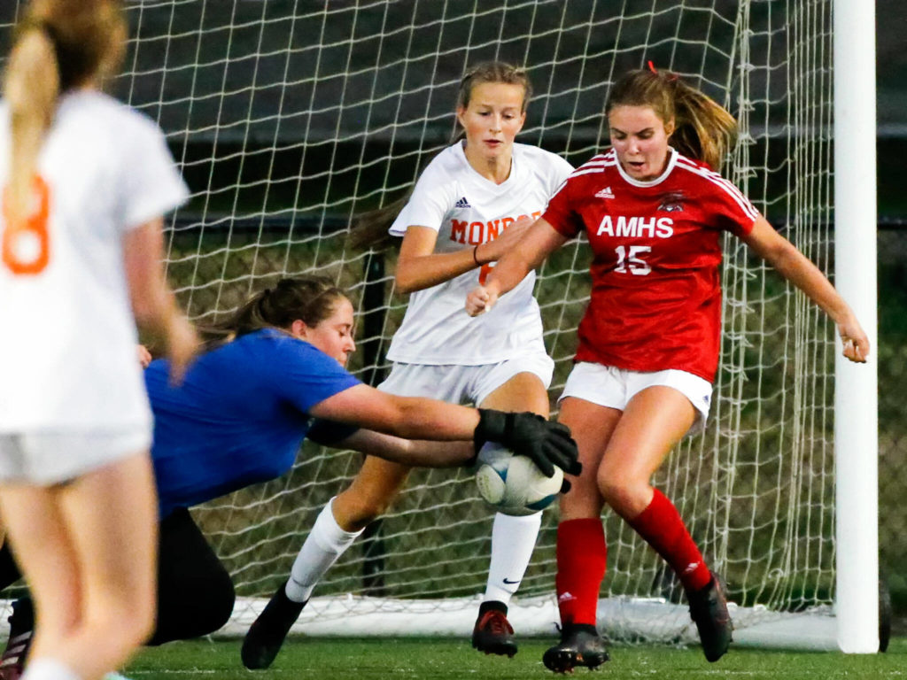 Monroe’s Jade Relkoff stops a shot at goal with teammate Faith Gunter and Archbishop Murphy’s Jordyn Latta looking on Thursday night at Archbishop Murphy High School in Everett on September 23, 2021. (Kevin Clark / The Herald)
