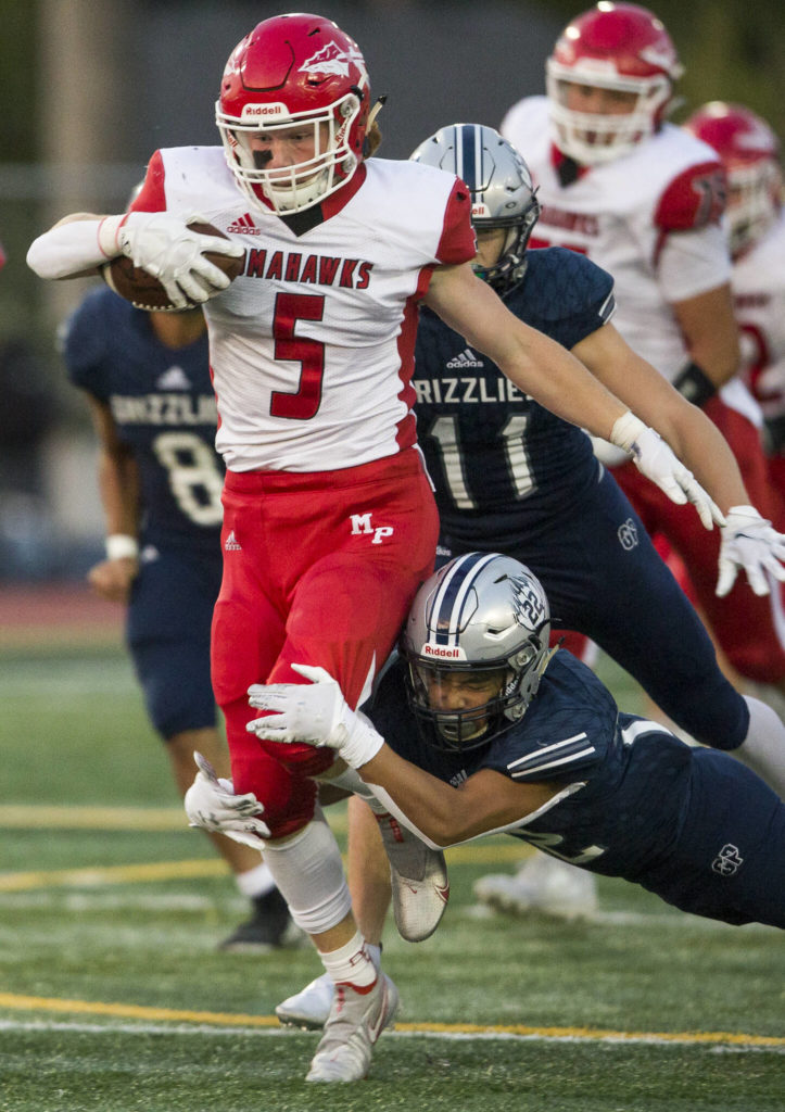 Marysville Pilchuck’s Dylan Carson is tackled by Glacier Peak’s Reggie Valmonte during a game on Friday in Snohomish. (Olivia Vanni / The Herald)
