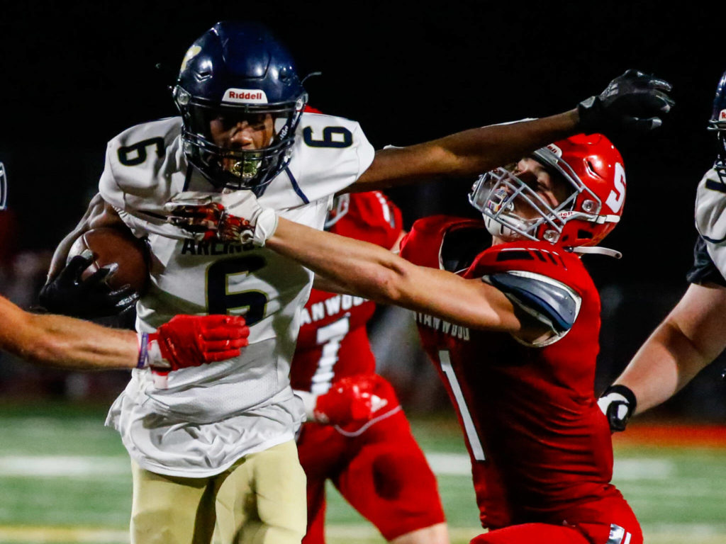 Arlington’s Elijah Jackson looks fights through the tackl attempt of Stanwood’s JT McLaughlin during the third quarter of the Stilly Cup on Friday night at Stanwood High School. (Kevin Clark / The Herald)
