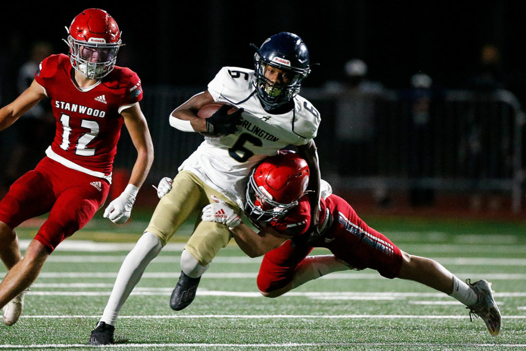 Stanwood’s Cam O’ Neill tackles Arlington’s Elijah Jackson during the Stilly Cup on Friday night at Stanwood High School. (Kevin Clark / The Herald)
