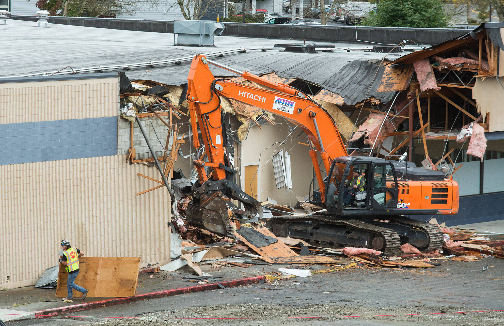 Crews demolish the strip mall at 10th and Broadway, near the Washington State University Everett campus, on Monday in Everett. (Andy Bronson / The Herald)