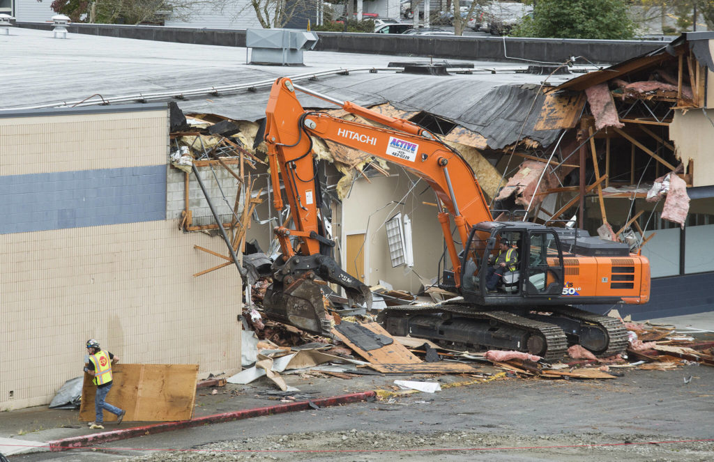 Crews demolish the strip mall at 10th and Broadway, near the Washington State University Everett campus, on Monday in Everett. (Andy Bronson / The Herald)
