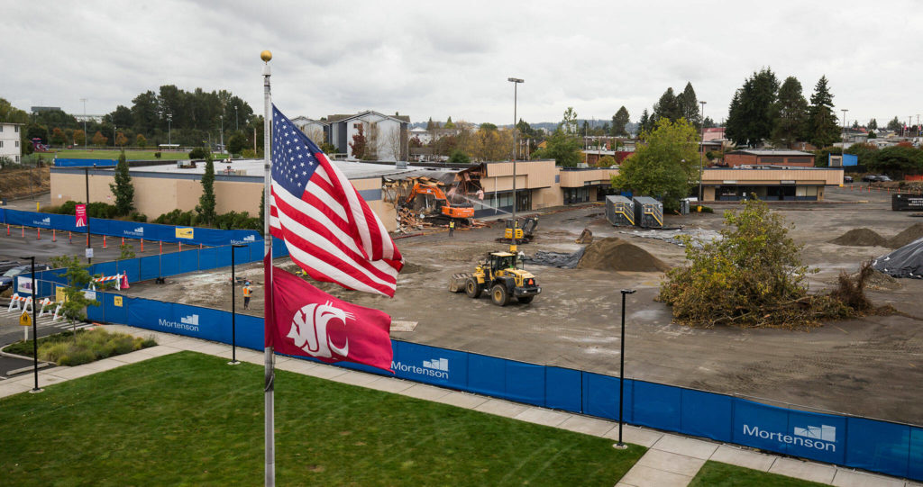 Crews demolish the strip mall near the Washington State University Everett campus Monday. (Andy Bronson / The Herald)
