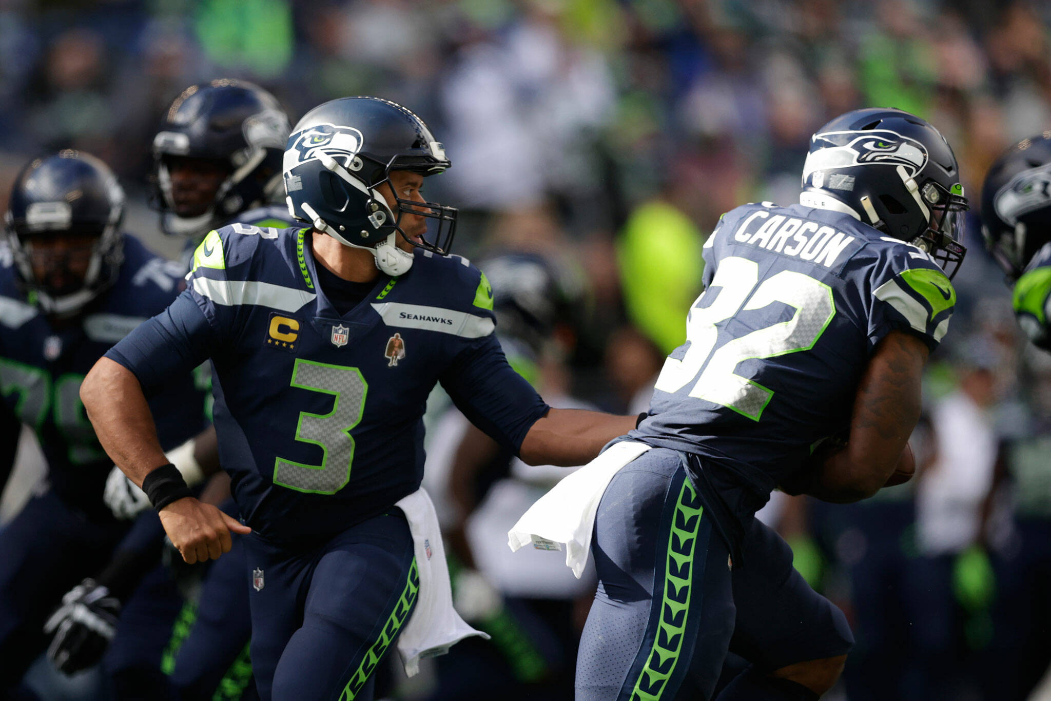 Seahawks quarterback Russell Wilson (3) hands off to running back Chris Carson during a game against the Titans on Sept. 19, 2021, in Seattle. (AP Photo/John Froschauer)