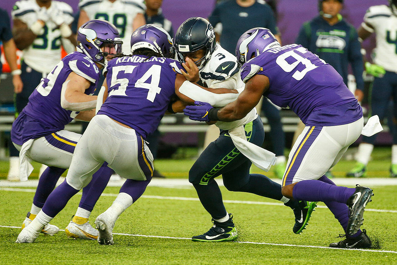 Seattle Seahawks quarterback Russell Wilson (3) is tackled by Minnesota Vikings middle linebacker Eric Kendricks (54) and defensive end Everson Griffen (97) in the second half of an NFL football game in Minneapolis, Sunday, Sept. 26, 2021. (AP Photo/Bruce Kluckhohn)