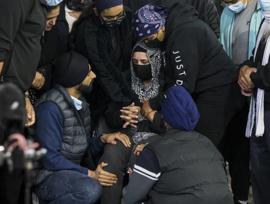 Jaswant Singh, whose husband TejPal Singh was shot and killed while he worked Sunday, is consoled by family and friends during his candlelight vigil Wednesday in Lynnwood. (Olivia Vanni / The Herald)
