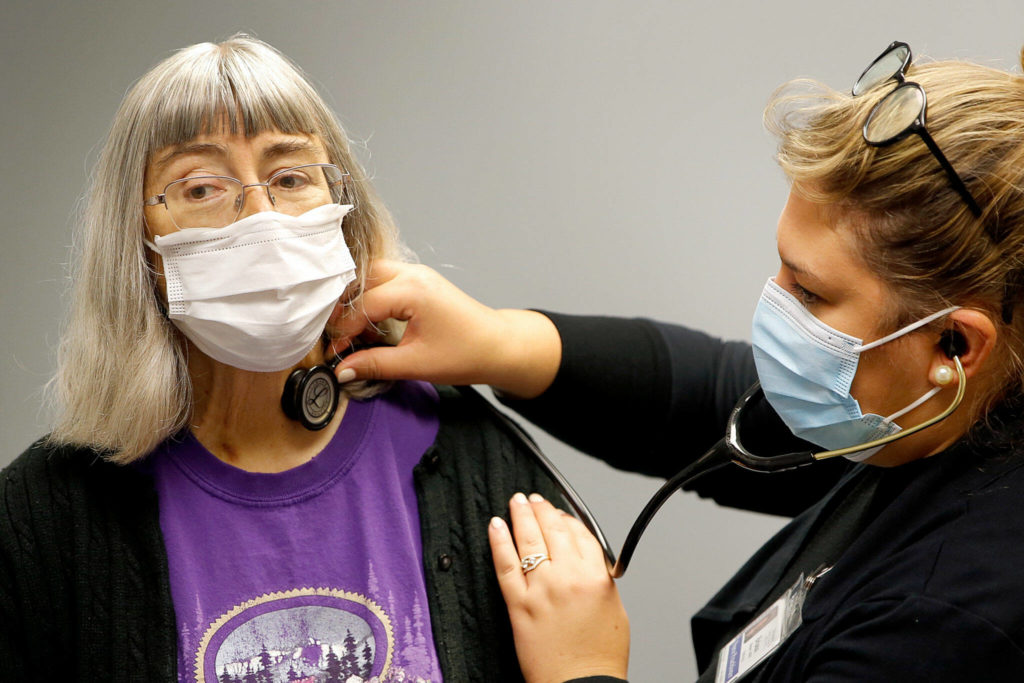 Deena Jones is examined by Briana Brewer at UW Medicine in Seattle on Sept. 30. (Kevin Clark / The Herald)
