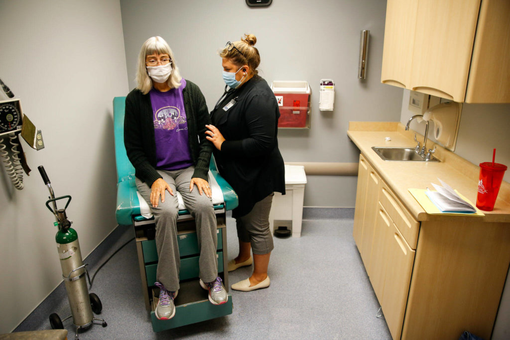 Deena Jones is examined by Briana Brewer at UW Medicine in Seattle on Sept. 30. (Kevin Clark / The Herald)
