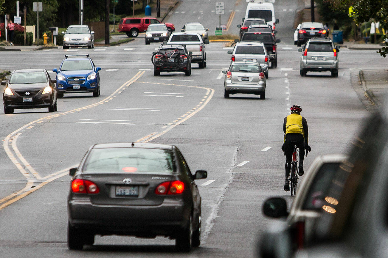 A bicyclist navigates car traffic while riding south along 100th Avenue West toward the intersection with Highway 104 on Tuesday, Sept. 28, 2021 in Edmonds, Wa. (Olivia Vanni / The Herald)