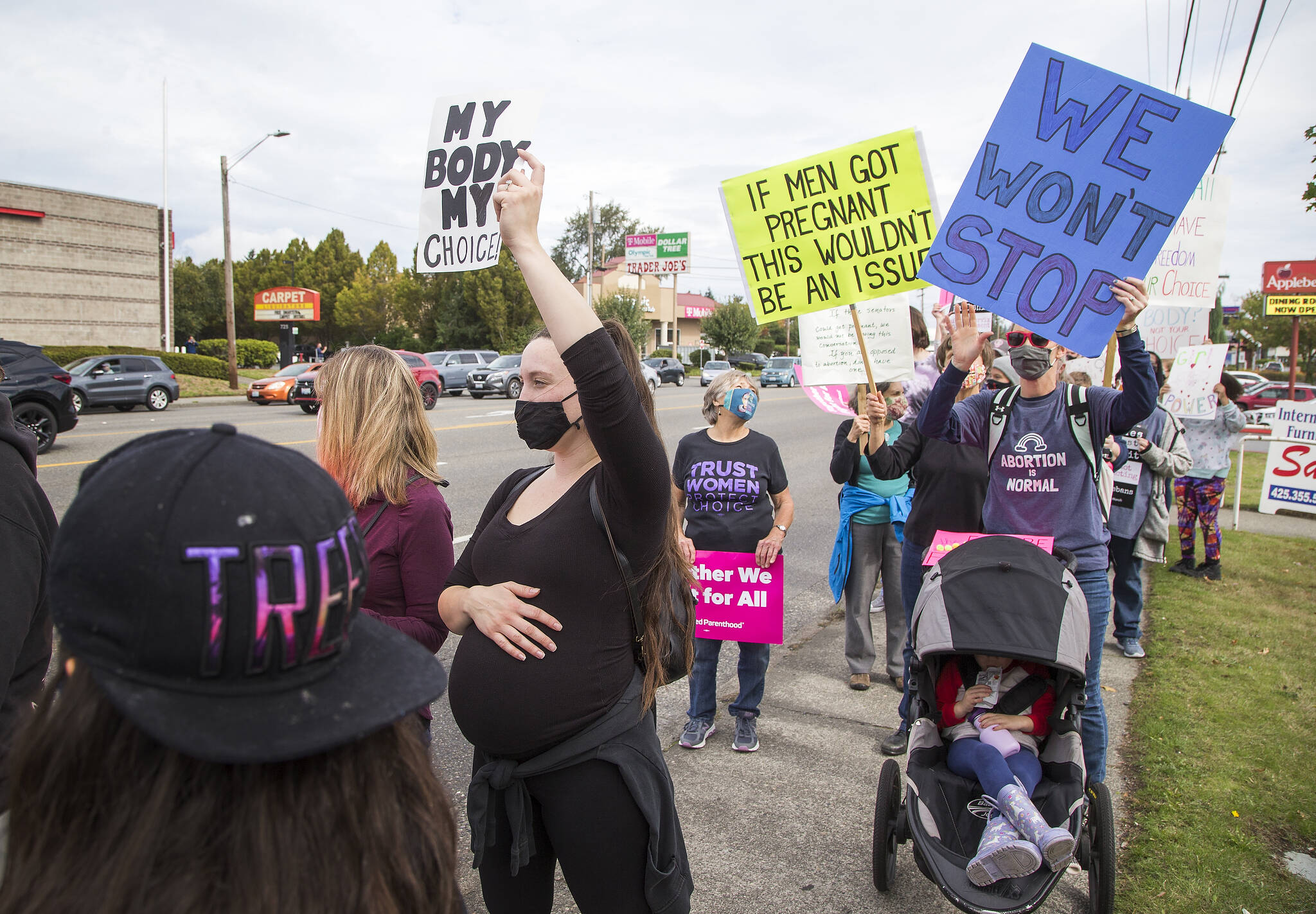 Visibly pregnant, Allison Stone holds up a sign Saturday during a march for reproductive rights along Highway 99 in Everett. (Andy Bronson / The Herald)