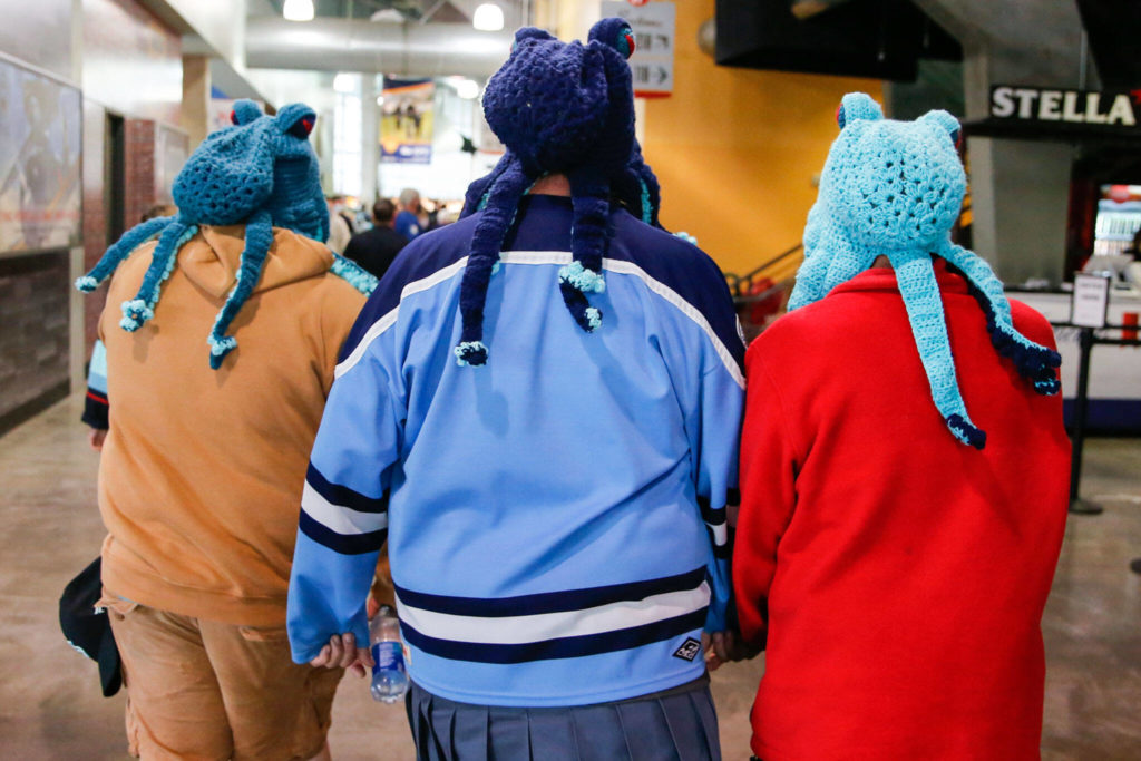Fans in Kraken-themed knitted hats arrive at the Angel of the Winds Arena in Everett. (Kevin Clark / The Herald)
