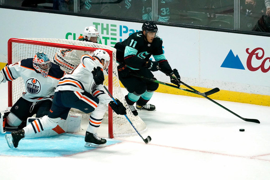 Seattle Kraken’s Alexander True (11) skates behind the Edmonton Oilers’ net in the first period of a pre-season NHL hockey game Friday in Everett. (AP Photo/Elaine Thompson)
