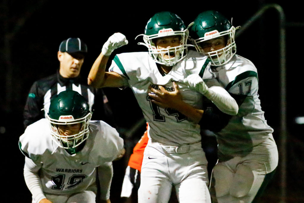 Edmonds-Woodway’s George Quintans, left to right, Major Gradwohl and John Morales celebrates an interception Friday night at Monroe High School on October 1, 2021. (Kevin Clark / The Herald)
