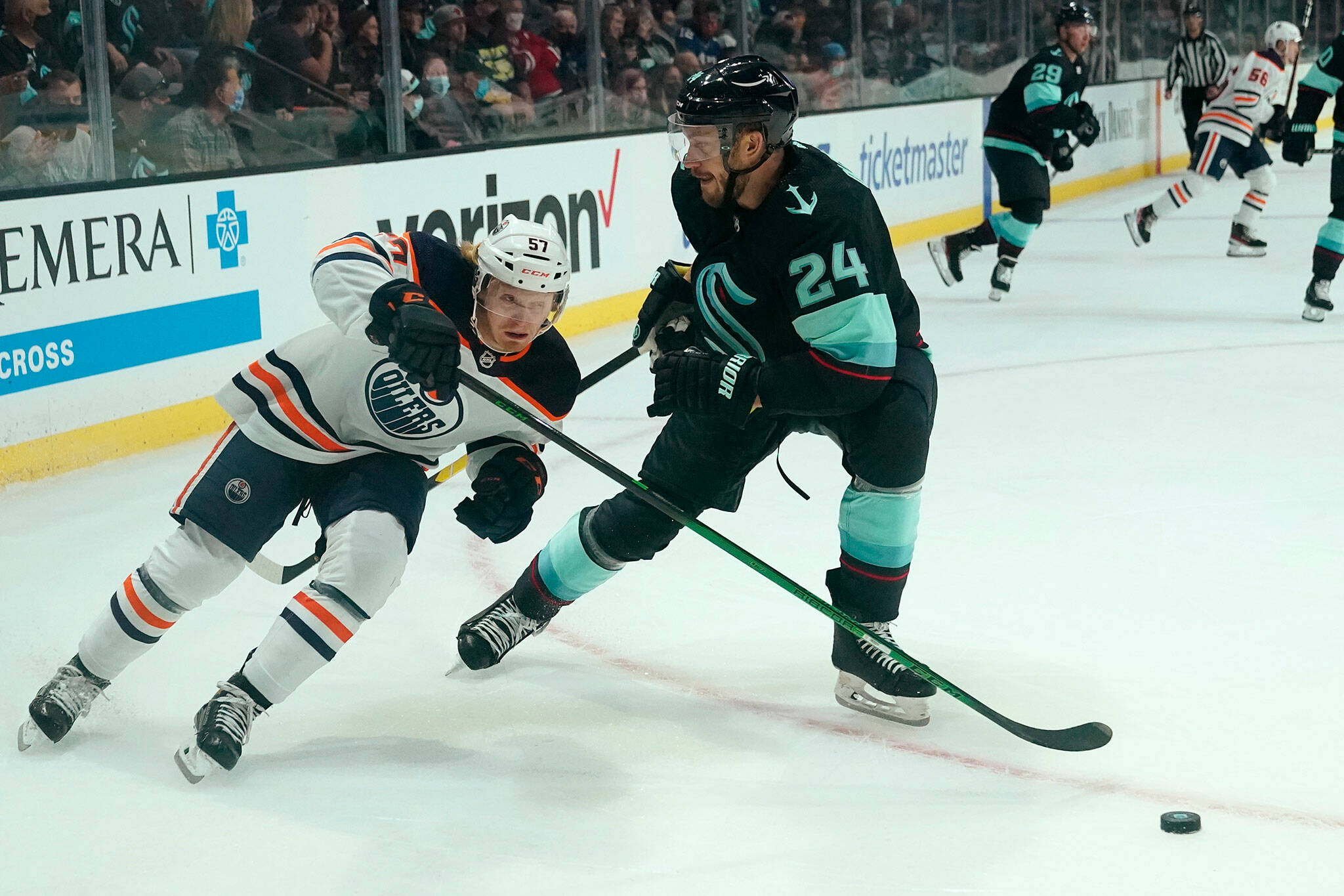 The Oilers’ James Hamblin (left) skates past the Kraken’s Jamie Oleksiak in the first period of a preseason game Friday at Angel of the Winds Arena in Everett. (AP Photo/Elaine Thompson)