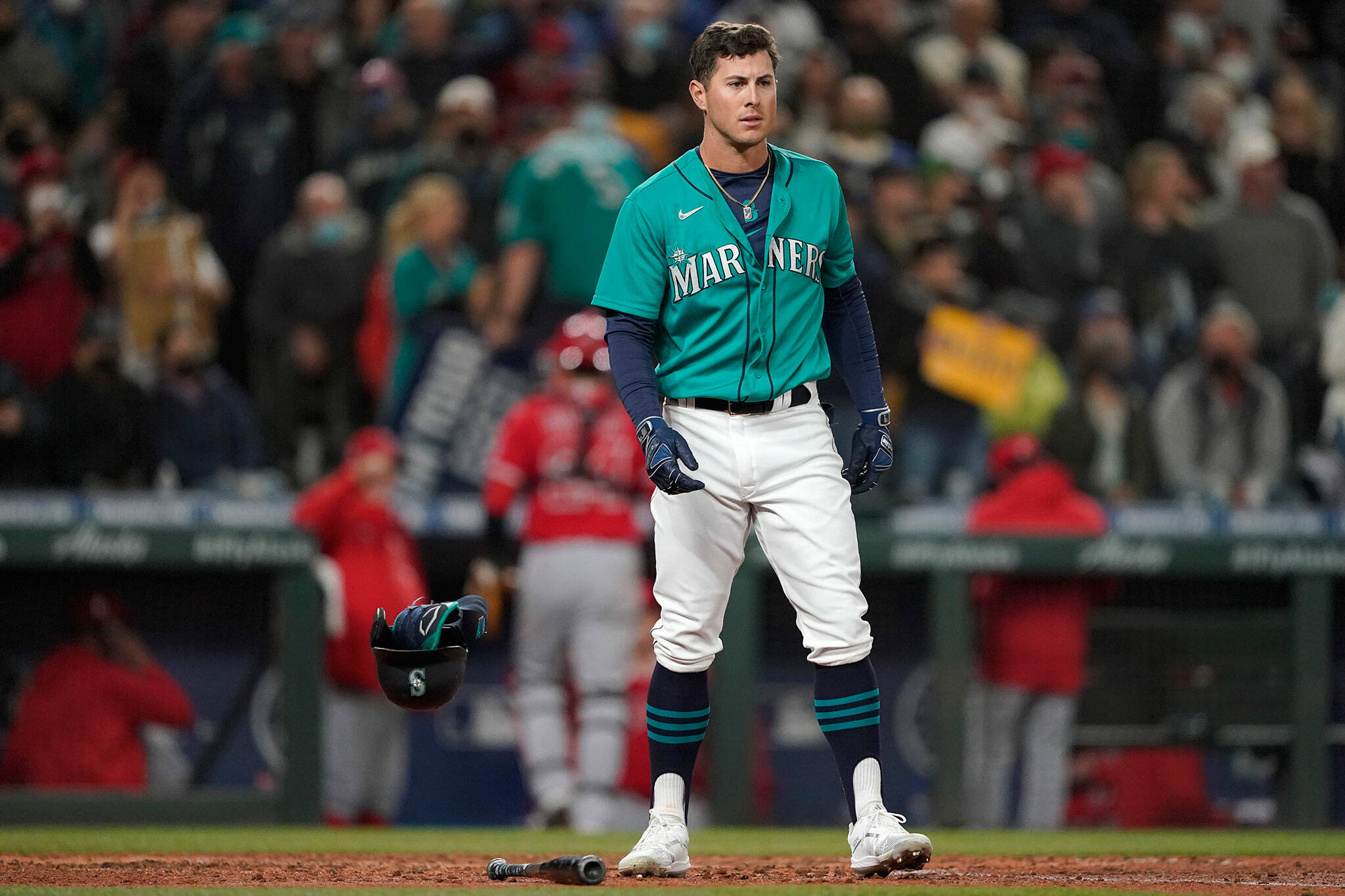 The Mariners’ Dylan Moore drops his batting helmet as he reacts after being called out on strikes to end the seventh inning of a game against the Angels on Friday in Seattle. (AP Photo/Ted S. Warren)