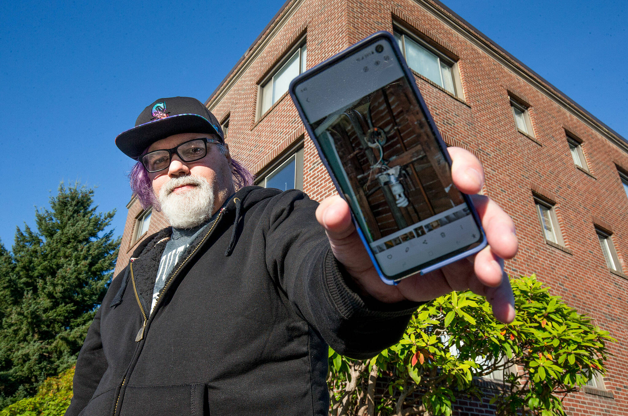 With new owners demanding the Grand Apartments’ longtime residents leave, Stephen Teixeira, 52, documents issues at the Rockefeller Avenue building, on Thursday, Oct. 7, 2021 in Everett, Washington. (Andy Bronson / The Herald)