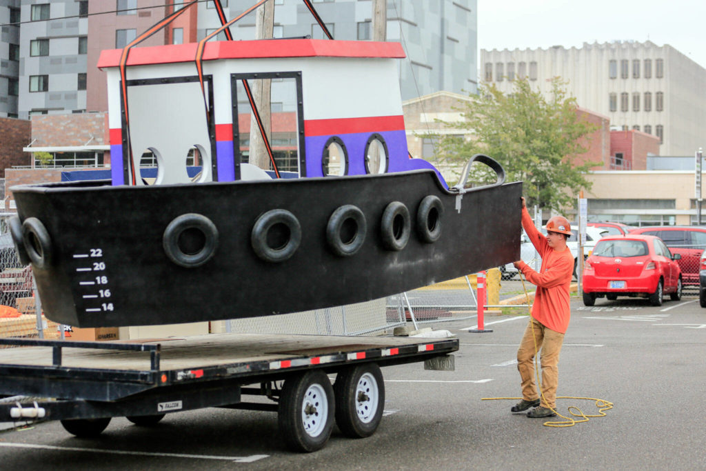 A model tugboat exhibit is hoisted Sept. 27 into the expansion of the Imagine Children’s Museum in Everett. (Kevin Clark / The Herald)
