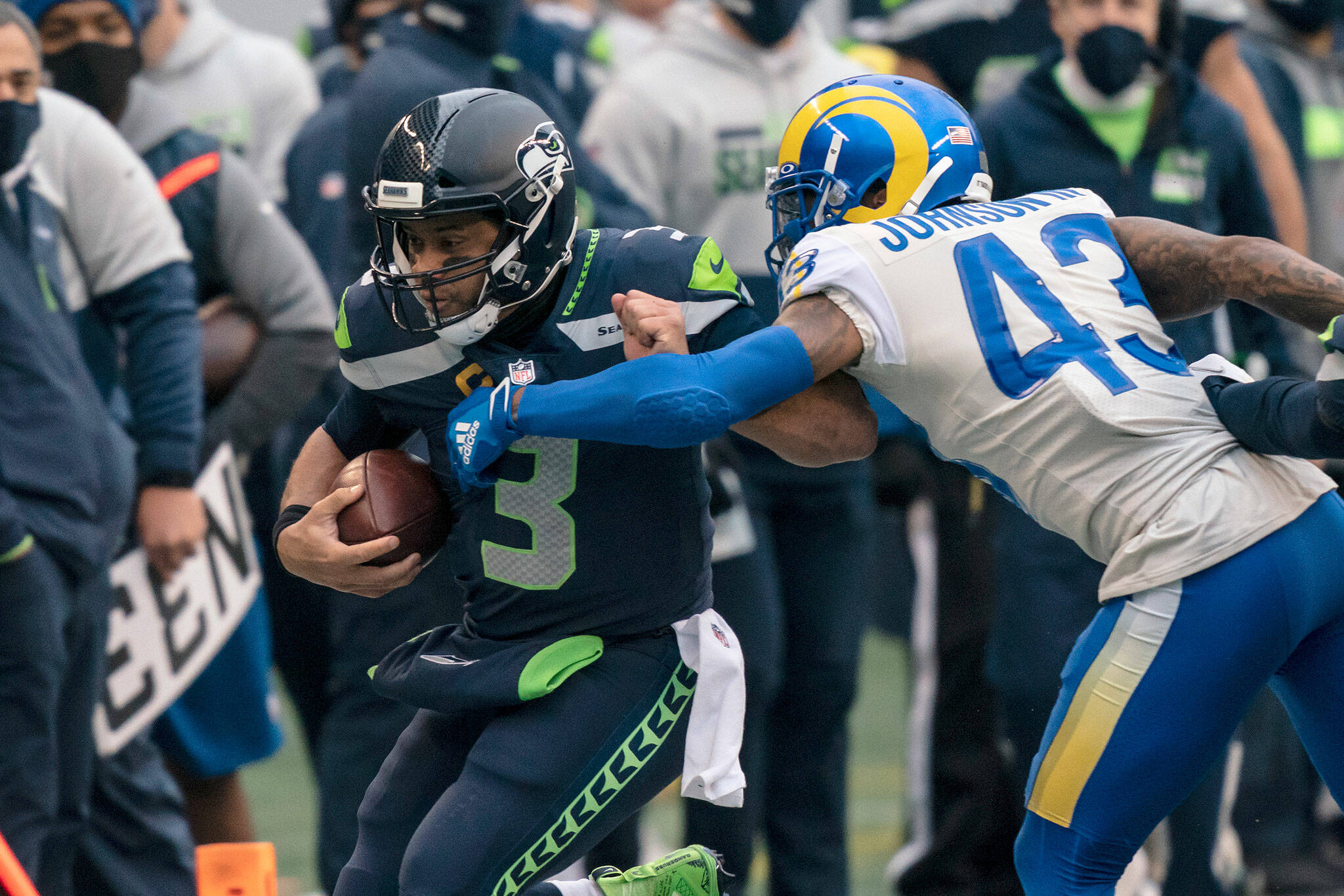 Seahawks quarterback Russell Wilson is pushed out of bounds by Rams safety John Johnson III during the first half of a playoff game on Jan. 9, 2021, in Seattle. The Rams won 30-20. (AP Photo/Stephen Brashear)