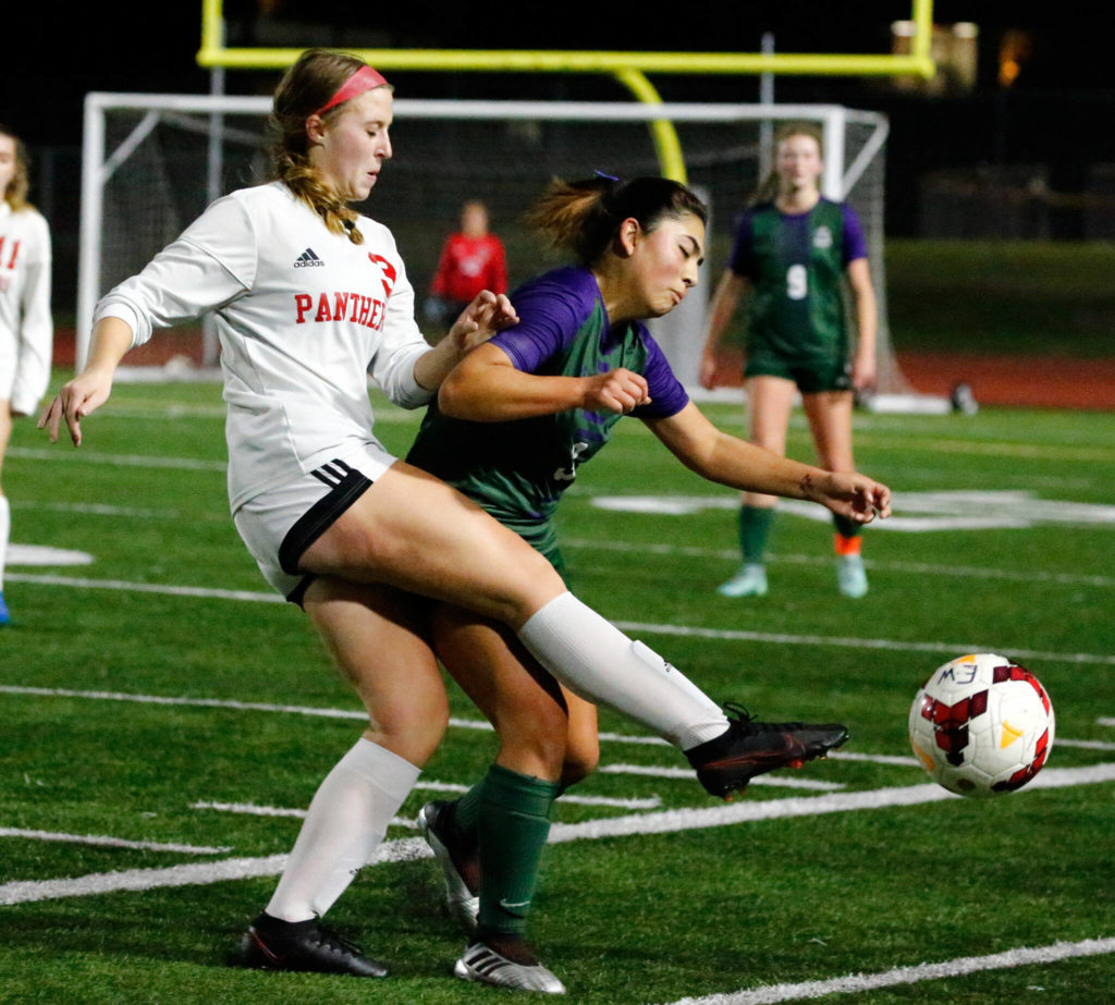 Snohomish’s Sara Rodgers kicks past Edmonds-Woodway’s Amalia Takahashi Thursday night at Edmonds-Woodway High School in Edmonds on October 7, 2021. (Kevin Clark / The Herald)
