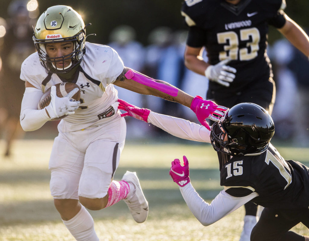 Everett’s JuJu Williams escapes a tackle by Lynnwood’s Andrew Archide during a game on Friday in Edmonds. (Olivia Vanni / The Herald)
