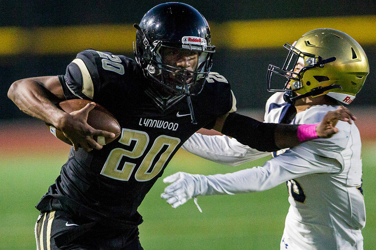 Lynnwood's Jordan Whittle sticks his arm out to block a tackle during the game against Everett on Friday, Oct. 8, 2021 in Edmonds, Wa. (Olivia Vanni / The Herald)