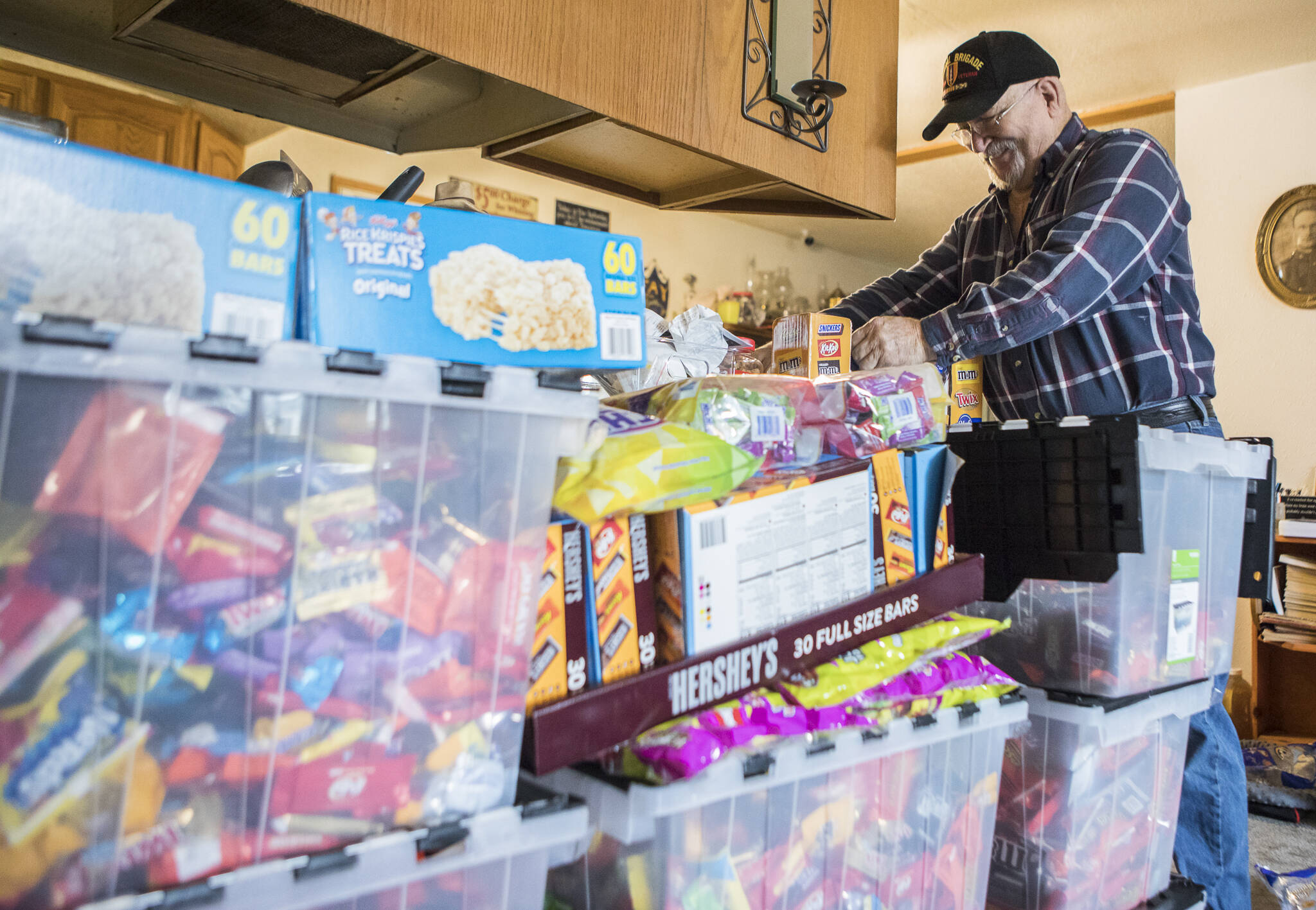 Stephen Fay prepares to dump candy into a large storage container at his home Friday in Marysville. (Olivia Vanni / The Herald)