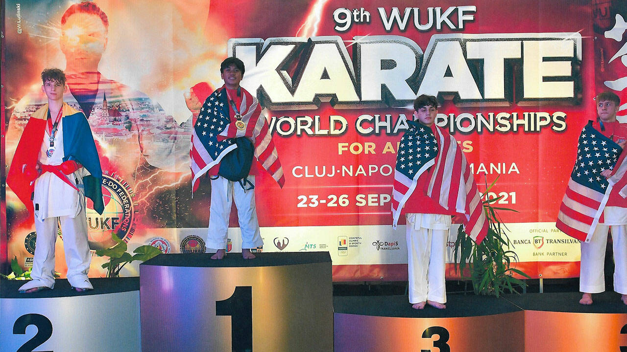 Lawrence Muhat (center), of Lake Stevens, stands on the podium after winning the Kumite gold medal at the WUKF World Karate Championships held Sept. 23-26 in Cluj-Napoca, Romania. (Photo courtesy of the Muhat family)