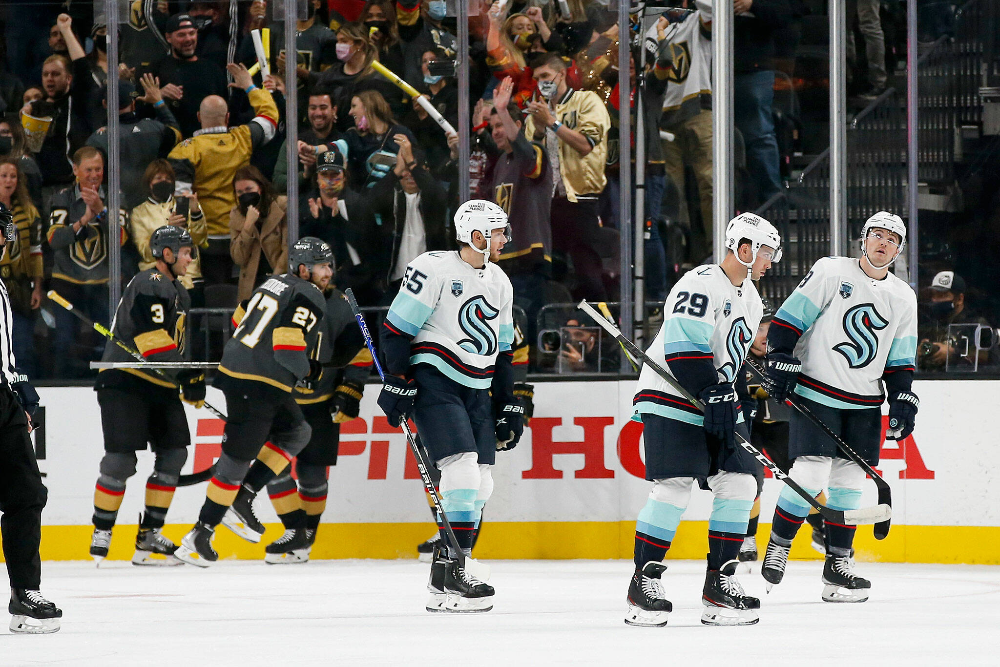 Kraken defensemen Jeremy Lauzon (55) and Vince Dunn (29) and center Ryan Donato skate off the ice after the Golden Knights scored a goal during the first period of a game Tuesday in Las Vegas. (AP Photo/Chase Stevens)