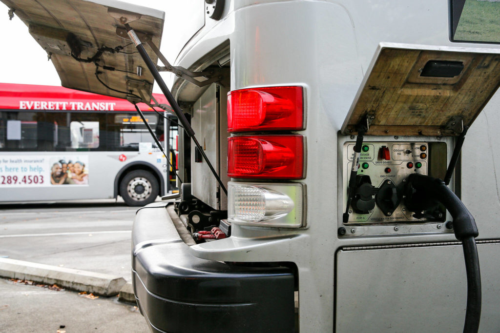 An electric bus charges before its next route Friday afternoon at the Everett Transit depot in Everett. Inductive charging stations are planned for installation next year. (Kevin Clark / The Herald)
