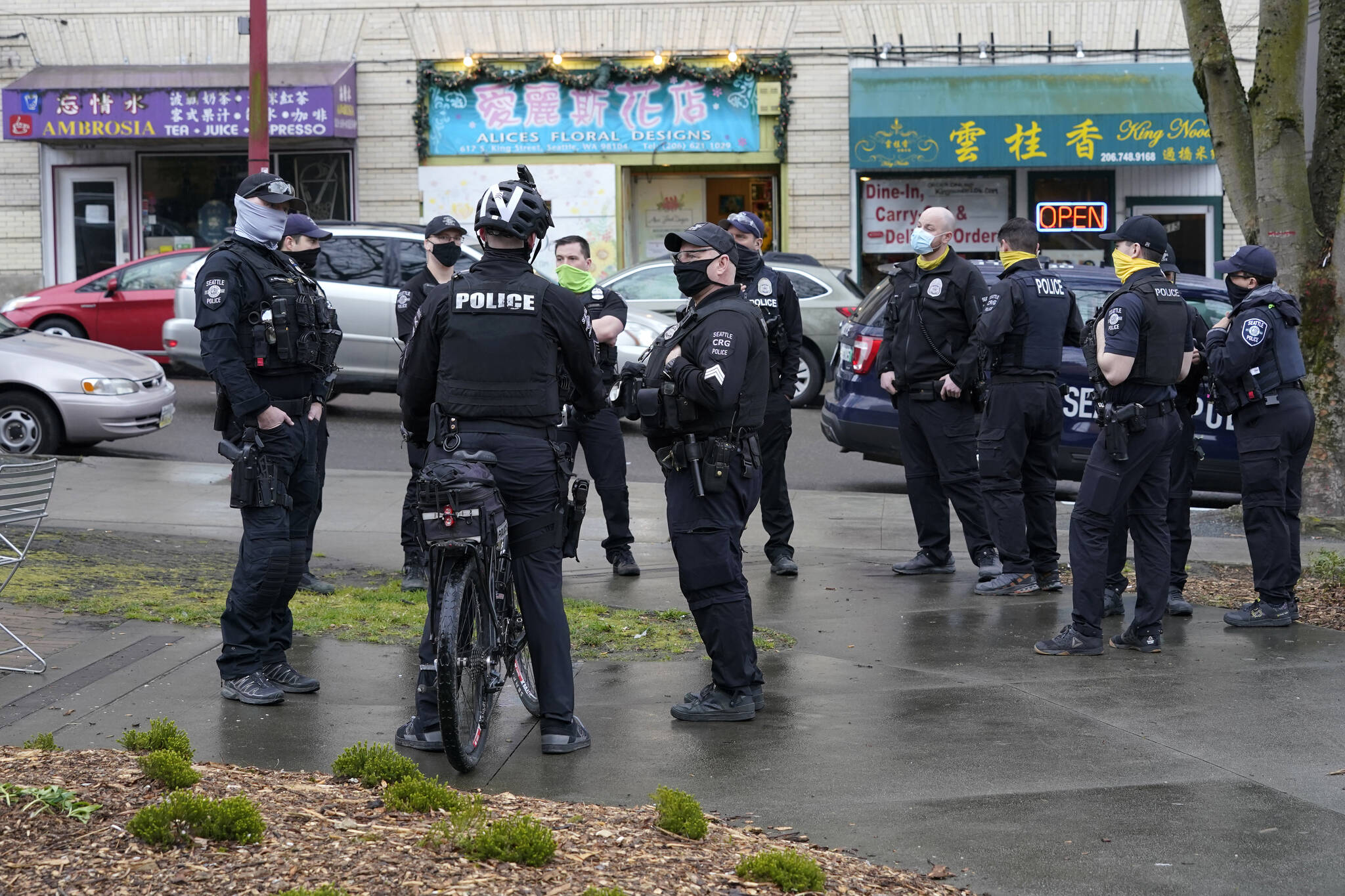Seattle Police officers confer after taking part in a public roll call at Hing Hay Park in Seattle’s Chinatown-International District on March 18. (AP Photo/Ted S. Warren, File)