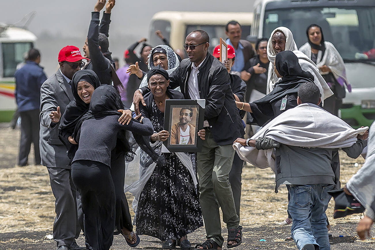 FILE - In this March 14, 2019 file photo, Ethiopian relatives of crash victims mourn at the scene where the Ethiopian Airlines Boeing 737 Max 8 crashed shortly after takeoff killing all 157 on board, near Bishoftu, south-east of Addis Ababa, in Ethiopia. Relatives of some of the passengers who died in the crash will mark the two-year anniversary of the disaster on Wednesday, March 10, 2021, by seeking a reversal of government orders that let Boeing 737 Max jets fly again.  (AP Photo/Mulugeta Ayene, File)