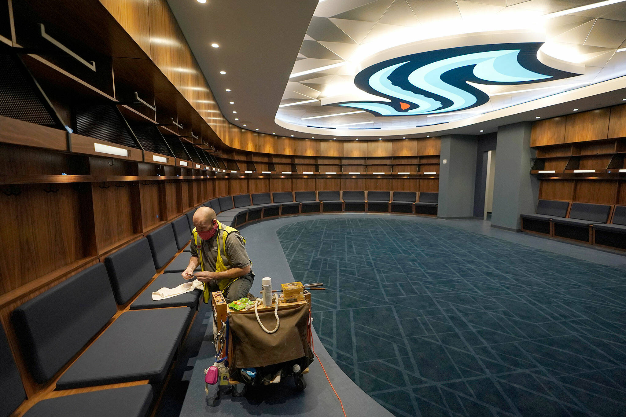 A worker puts the final touches on woodwork in the Seattle Kraken’s locker room at Climate Pledge Arena on Wednesday during a media tour ahead of the team’s home opener Saturday against the Vancouver Canucks in Seattle. (AP Photo/Ted S. Warren)
