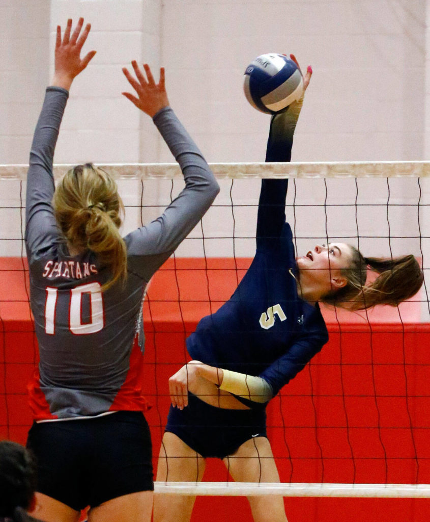 Stanwood’s Cailyn Conley jumps to block a kill attempt by Arlington’s Emily Mekelburg Thursday night at Stanwood High School on October 21, 2021. (Kevin Clark / The Herald)
