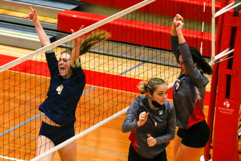 Arlington’s Malia Shepherd celebrates a kill against Stanwood’s Jolene Henrikson and Stanwood’s Grace Henken Thursday night at Stanwood High School on October 21, 2021. (Kevin Clark / The Herald)
