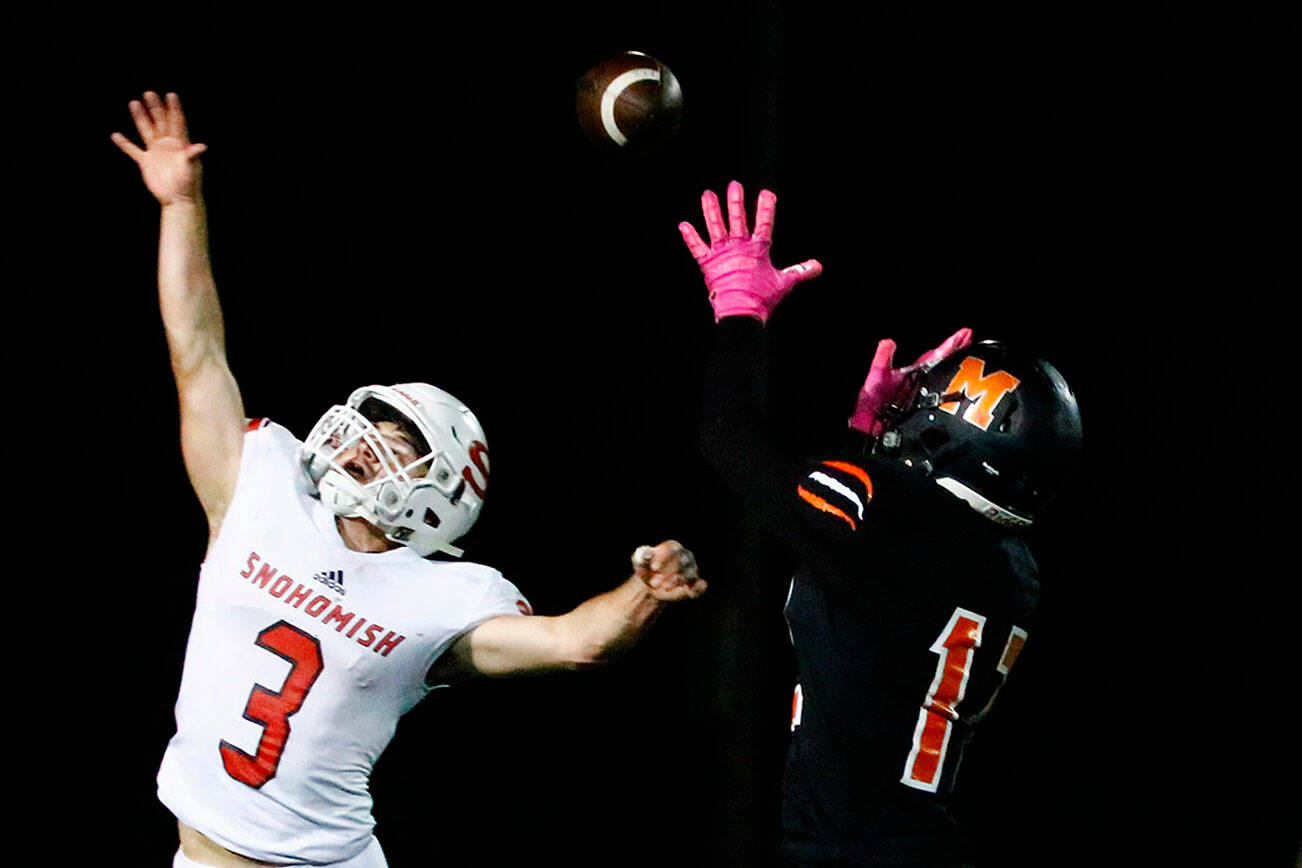 Monroe's Iseah Canizales attempts a reception over Snohomish's Joshua Vandergriend Friday night at Monroe High School on October 22, 2021.  (Kevin Clark / The Herald)