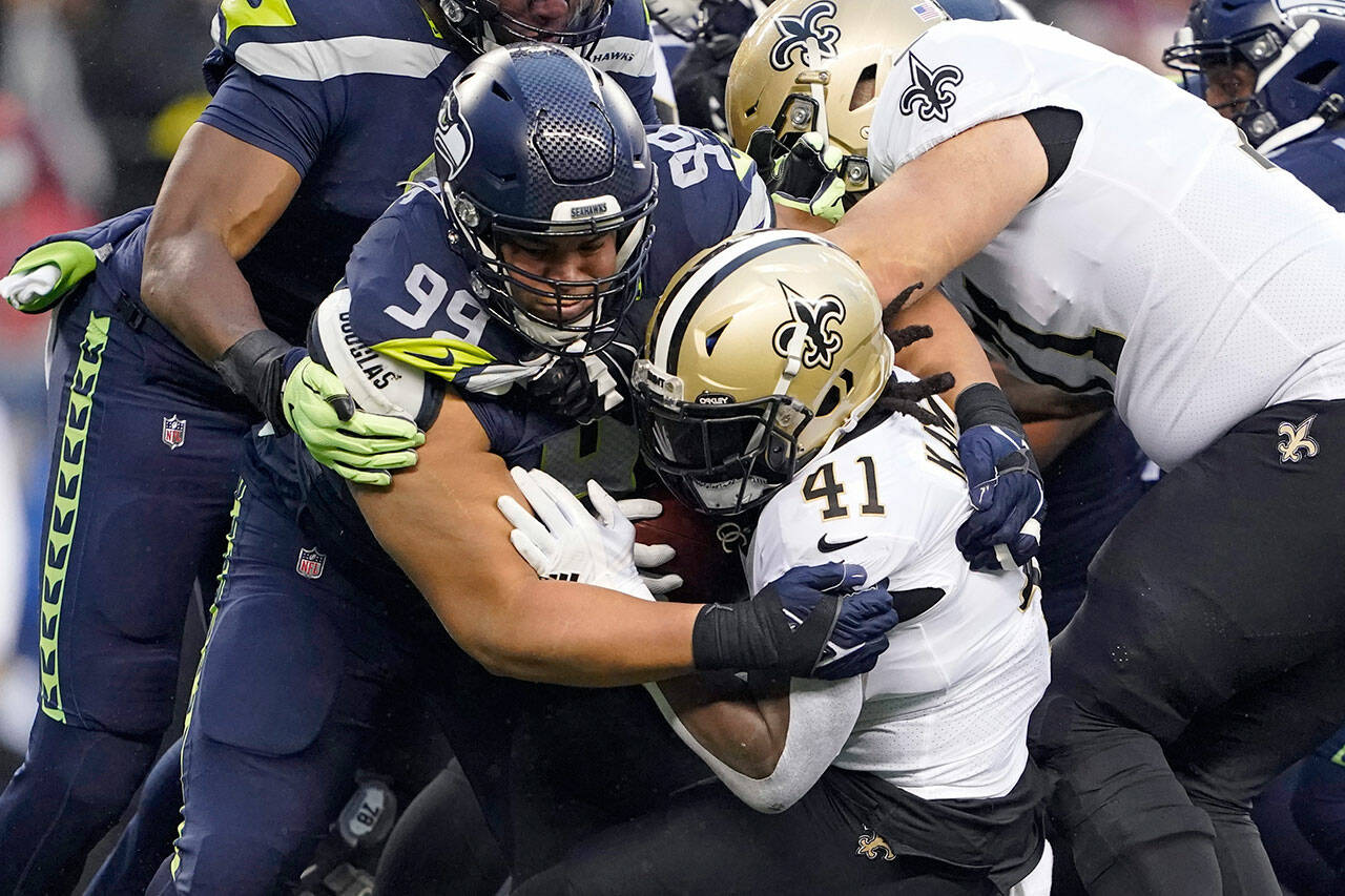 Seattle Seahawks defensive end Rasheem Green (94) brings down New Orleans Saints running back Alvin Kamara (41) during the first half of a game Monday in Seattle. (AP Photo/Ted S. Warren)