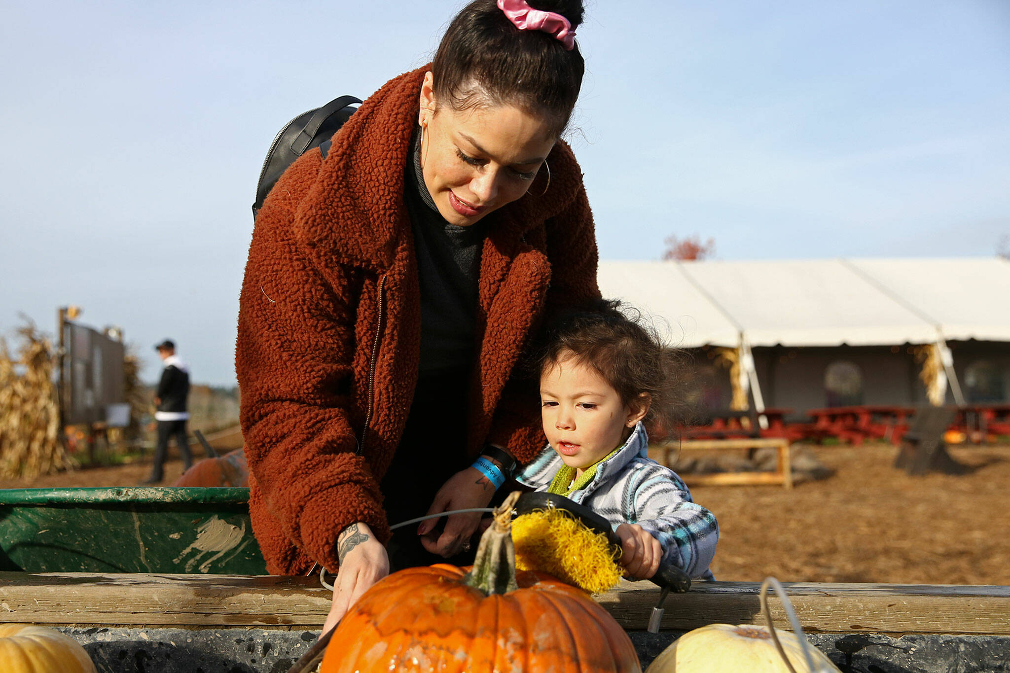 Rahayu So (left) and Bella So wash their picked pumpkins at Stocker Farms in Snohomish in 2019. Stocker Farms is one of seven farms participating in the annual Festival of Pumpkins, which runs through Oct. 31. (Kevin Clark / Herald file)
Rahayu So (left) and Bella So wash their picked pumpkins Wednesday afternoon at Stocker Farms in Snohomish on October 23, 2019. (Kevin Clark / The Herald)