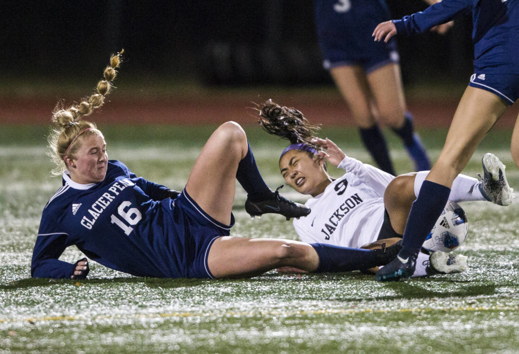 Glacier Peak’s Kate Sprink and Jackson’s Emilyn Pham both slide in for a tackle during the game Tuesday in Snohomish. (Olivia Vanni / The Herald)
