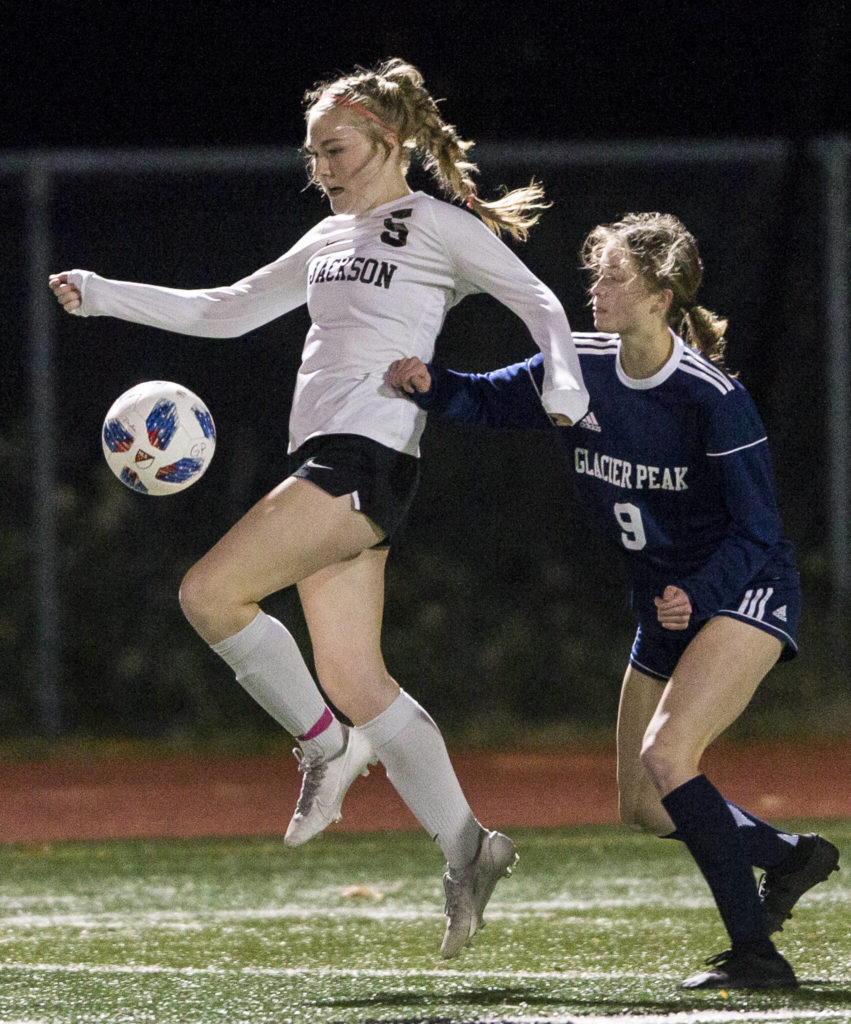Jackson’s Avery Friedricksen jumps to trap the ball during the game against Glacier Peak on Tuesday in Snohomish. (Olivia Vanni / The Herald)
